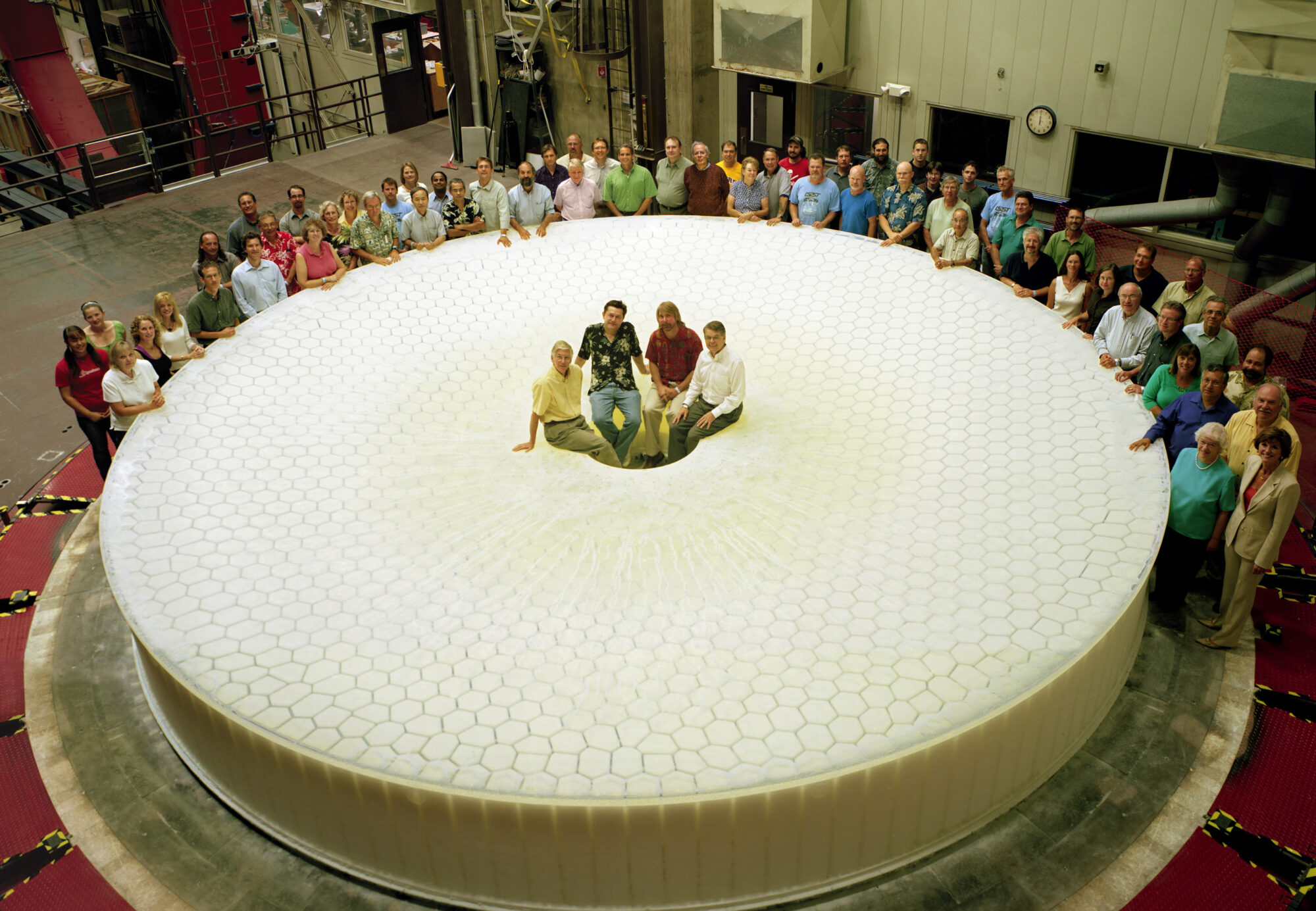 The construction team and engineers pose with the 8.4 meter (28 foot) main mirror.